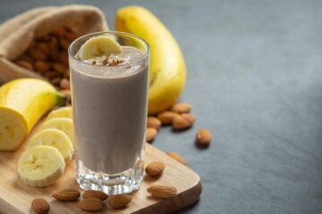 Low-carb protein shake made with bananas and almonds on a cutting board.